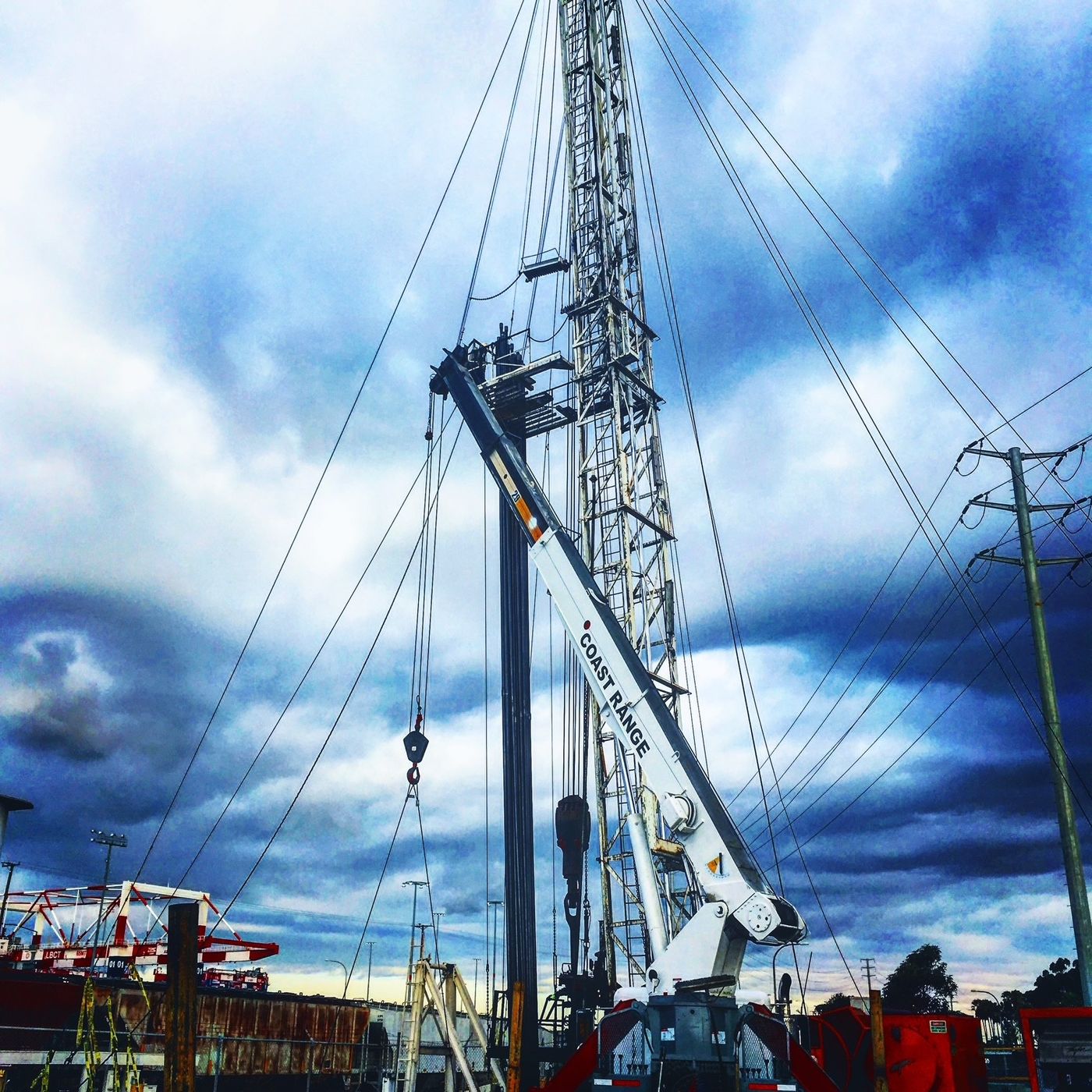 A Coast Range crane lowering its hook at a drilling rig
