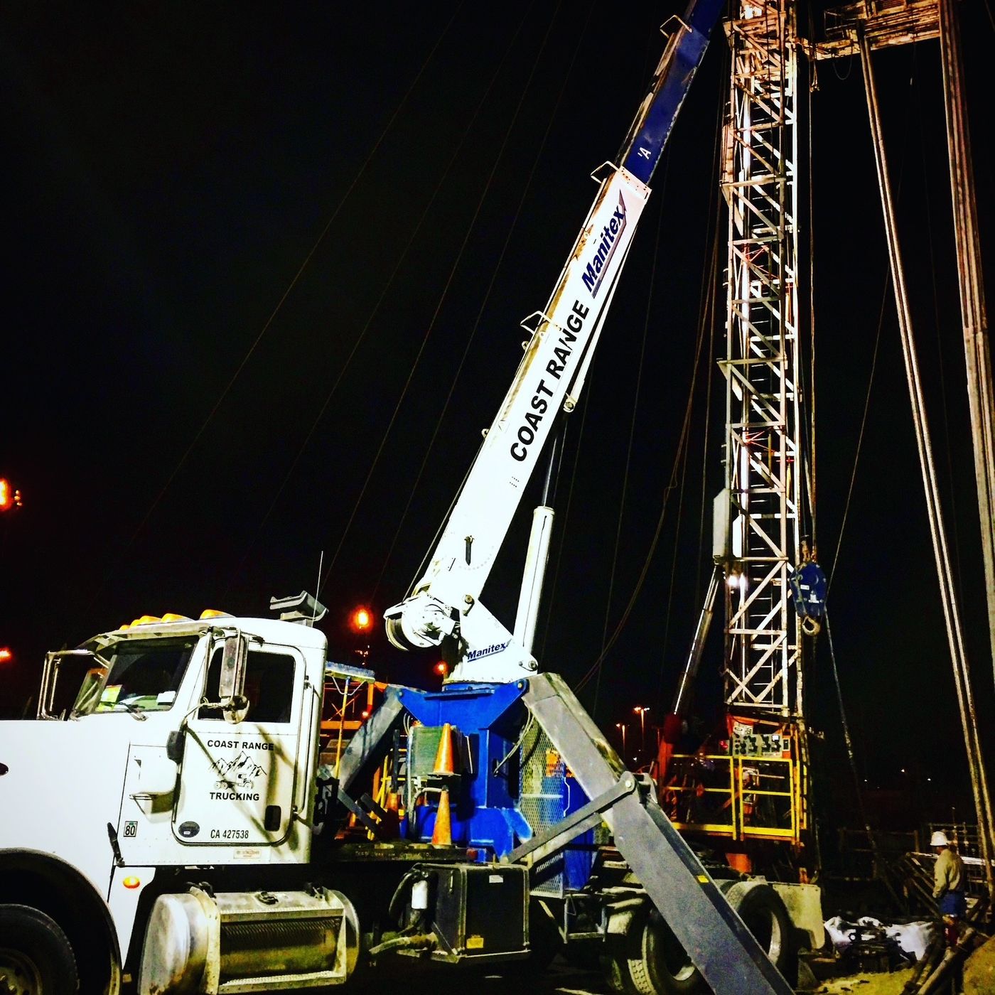 A Coast Range crane truck lifting at an oilfield rig