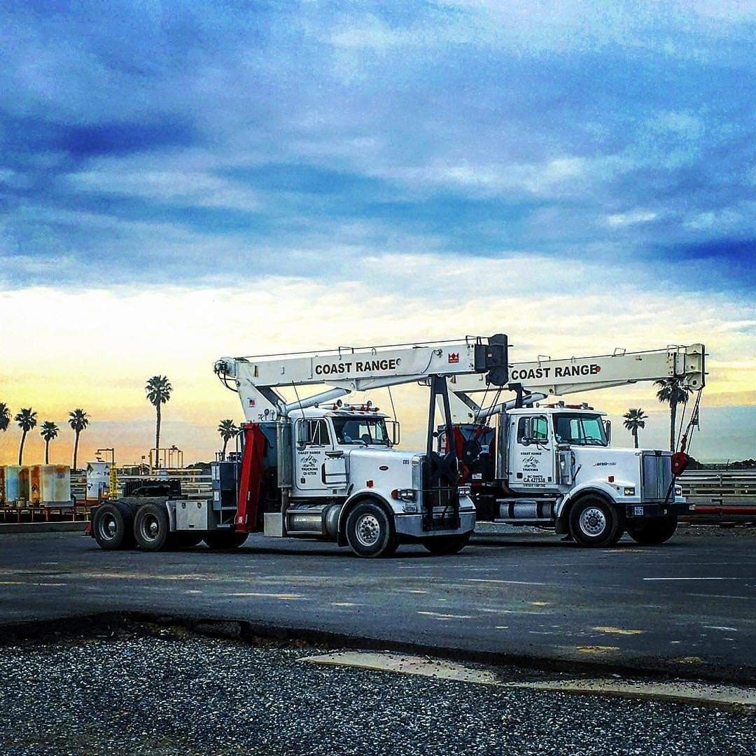 Two Coast Range Trucking crane trucks parked side by side